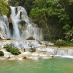 Laos travel guide featuring Kuang Si Falls multi-tiered turquoise waterfalls near Luang Prabang with lush jungle surroundings